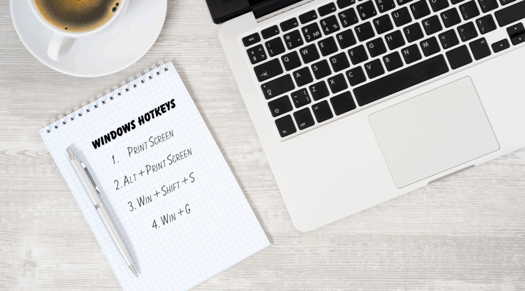 Windows hotkeys for screenshot a single monitor written on a notepad next to a laptop