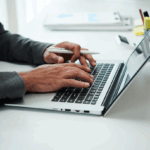 male hands typing on laptop keyboard