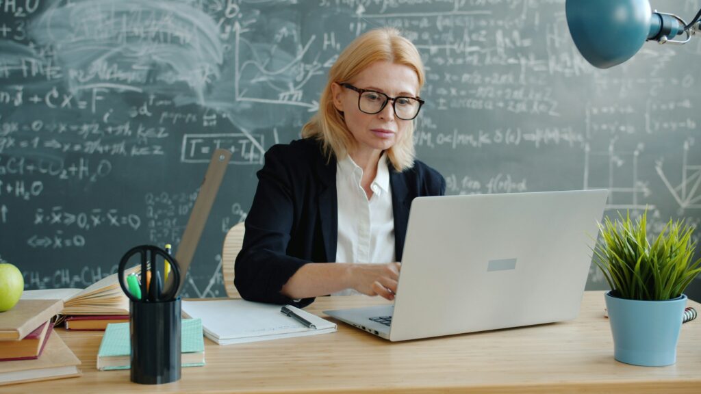 teacher in the classroom with a laptop
