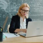 teacher in the classroom with a laptop